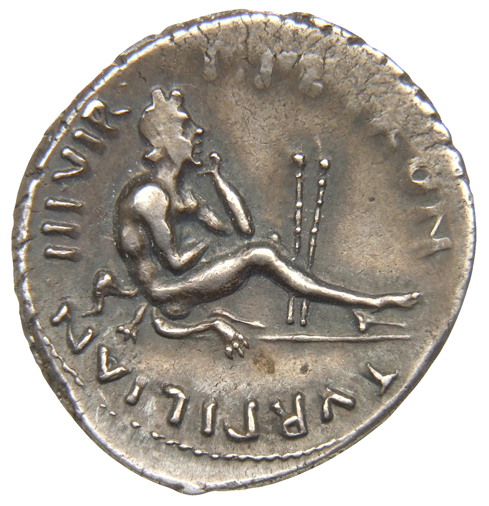 Augustus reverse — Young satyr seated right on ground resting chin on left hand, two flutes between his legs