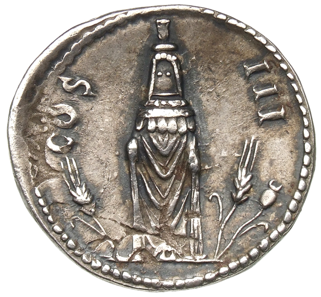 Hadrian reverse — Konisches Kultbild der Kore in der Vorderansicht, mit hohem Kopfschmuck (kalathos), Schleier und langem Gewand, das über die Handgelenke reicht. Im r. F. sind eine Ähre und eine Mohnkapsel und im l. F. nur eine Ähre.