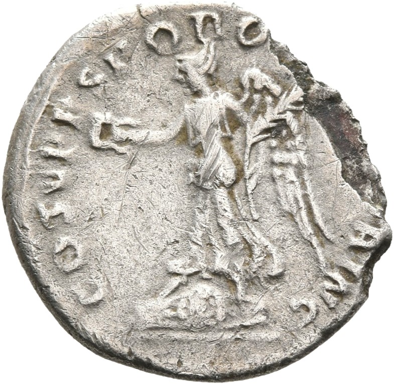 Trajan reverse — Victory, draped, walking left over a round and oblong shield, holding up wreath in right hand and palm, sloped up to right, in left