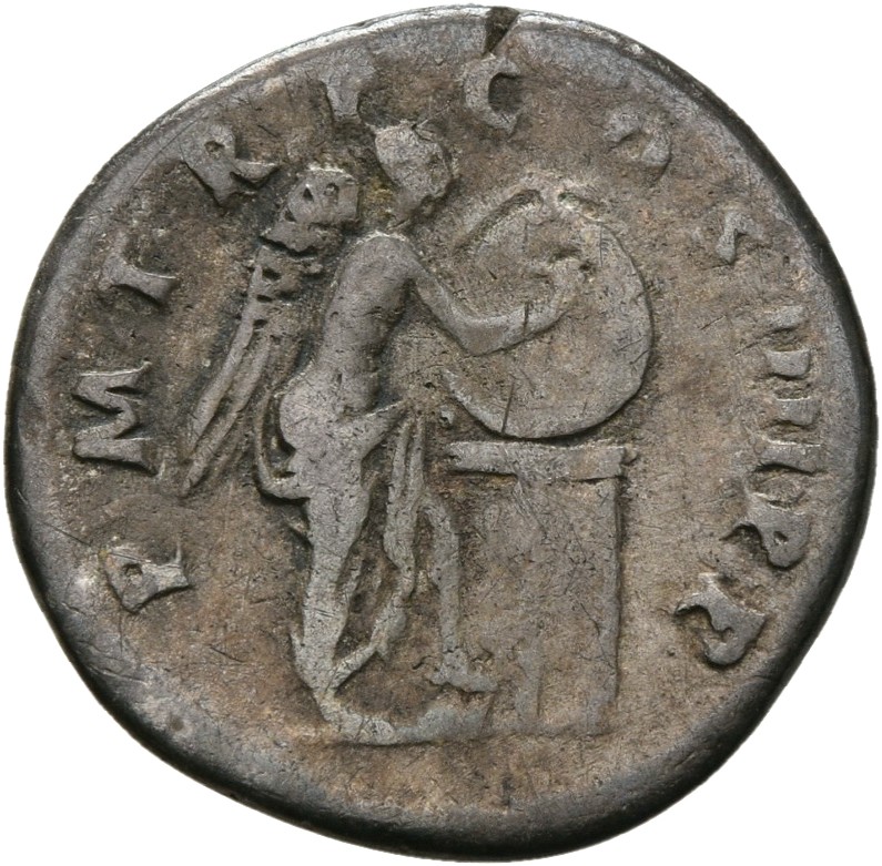RIC II Trajan 65 Trajan reverse, Victory standing right, resting foot on helmet, inscribing shield attached to base