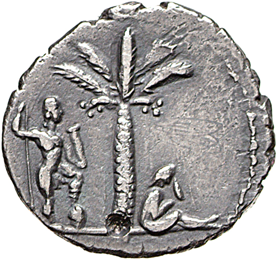 Vespasian reverse — Judaea, veiled, draped, seated right under palm-tree, in attitude of mourning; behind palm, Vespasian, in military dress, standing right, right foot on helmet, holding vertical spear in right hand and parazonium in left