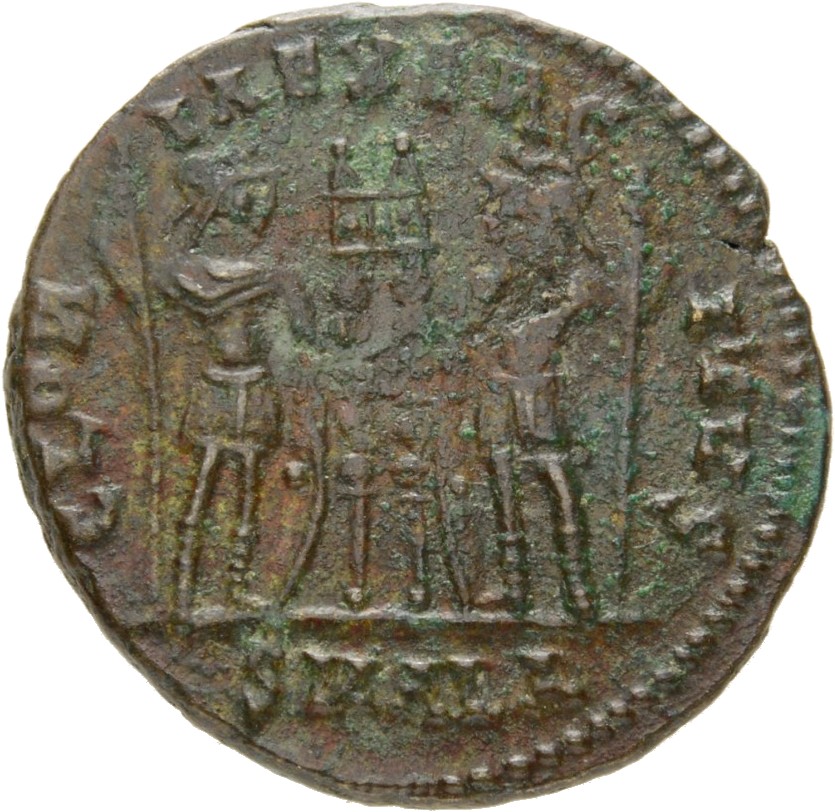 Constantine I reverse — Two soldiers, helmeted, draped, cuirassed, standing facing each other, each holding reversed spear in outer hand and resting inner hand on shield; between them, two standards