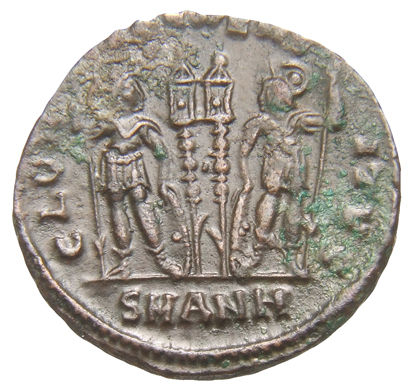 Constantine I reverse — Two soldiers, helmeted, draped, cuirassed, standing facing each other, each holding reversed spear in outer hand and resting inner hand on shield; between them, two standards
