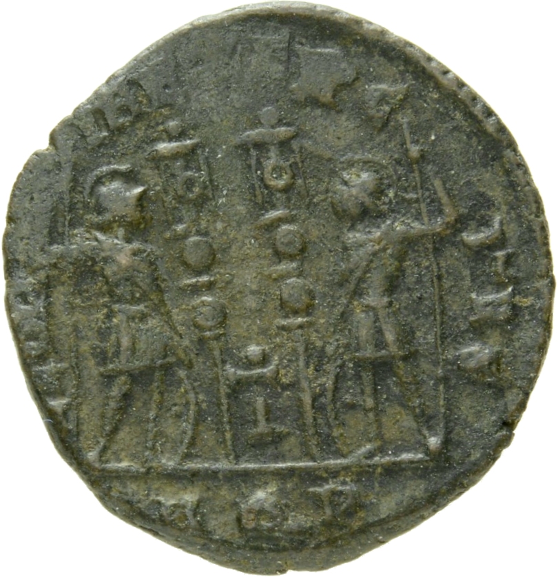 Constantine I reverse — Two soldiers, helmeted, draped, cuirassed, standing facing each other, each holding reversed spear in outer hand and resting inner hand on shield; between them, two standards