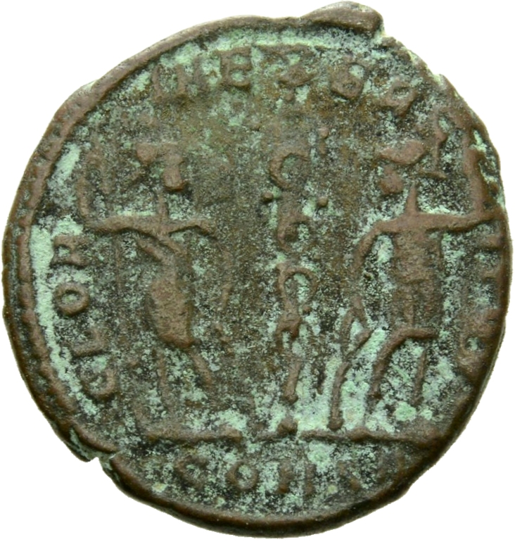 Constantine I reverse — Two soldiers, helmeted, draped, cuirassed, standing facing each other, each holding reversed spear in outer hand and resting inner hand on shield; between them, a standard