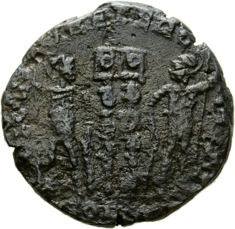Constantine I reverse — Two soldiers, helmeted, draped, cuirassed, standing facing each other, each holding reversed spear in outer hand and resting inner hand on shield; between them, two standards