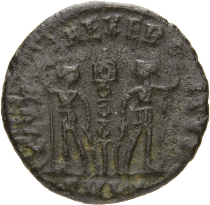 Constantine I reverse — Two soldiers, helmeted, draped, cuirassed, standing facing each other, each holding spear in outer hand and resting inner hand on shield; between them, a standard