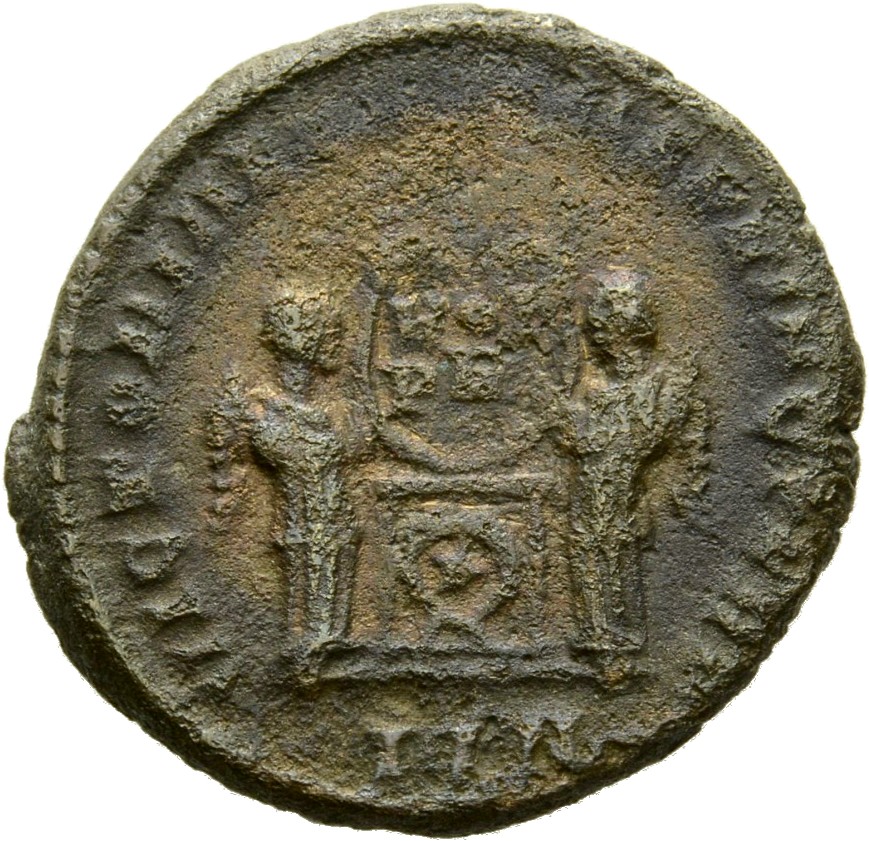 Constantine I reverse — Two Victories, winged, draped, facing each other, holding a wreath inscribed VOT/PR supported by an altar