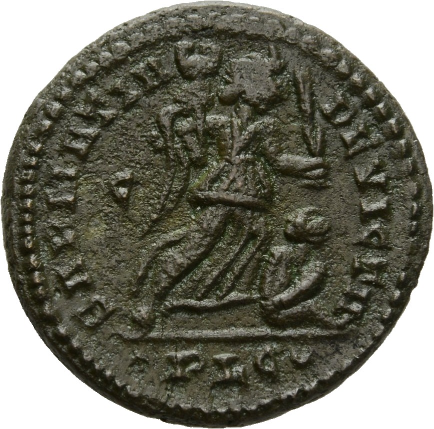 Constantine I reverse — Victory, winged, draped, advancing right, holding trophy on right arm and branch in left hand, spurning a seated captive