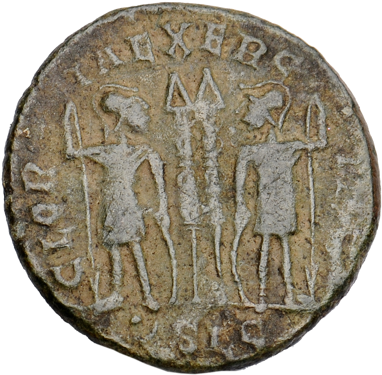 Constantine I reverse — Two soldiers, helmeted, draped, cuirassed, standing facing each other, each holding reversed spear in outer hand and resting inner hand on shield; between them, two standards