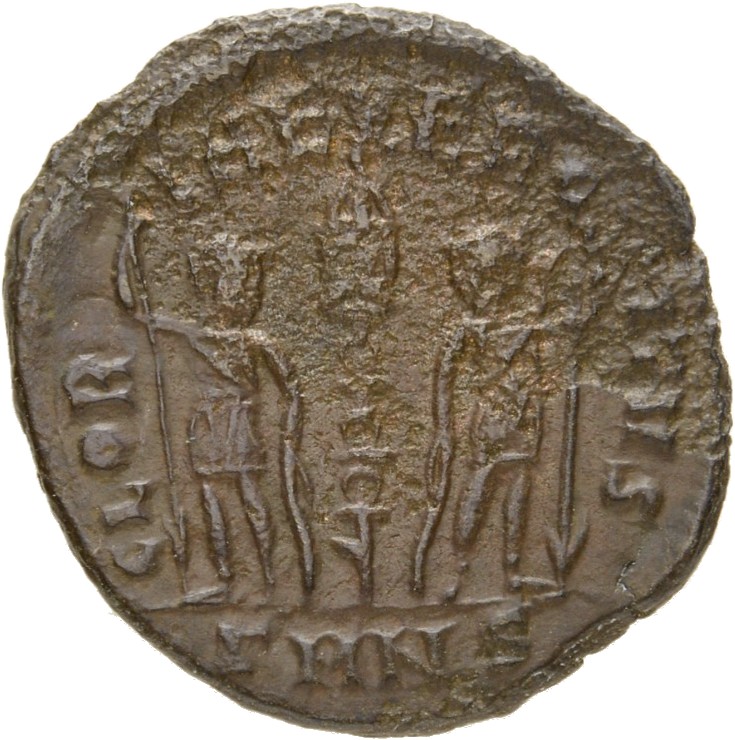 Constantine I reverse — Two soldiers, helmeted, draped, cuirassed, standing facing each other, each holding reversed spear in outer hand and resting inner hand on shield; between them, a standard