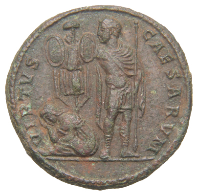 Constantine I reverse — Constantius II, draped, cuirassed, cloak spread, standing right, head left, erecting trophy with right hand and holding spear in left hand; to left of trophy, seated female figure