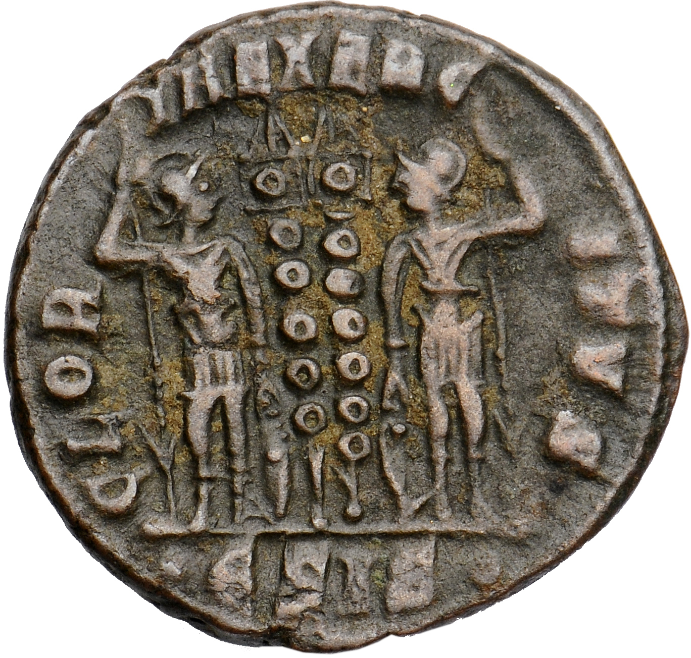 Constantine I reverse — Two soldiers, helmeted, draped, cuirassed, standing facing each other, each holding spear in outer hand and resting inner hand on shield; between them, two standards