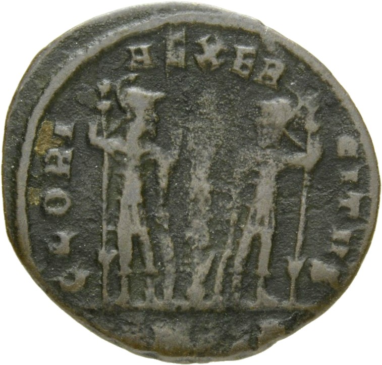 Constantine I reverse — Two soldiers, helmeted, draped, cuirassed, standing facing each other, each holding reversed spear in outer hand and resting inner hand on shield; between them, one standard