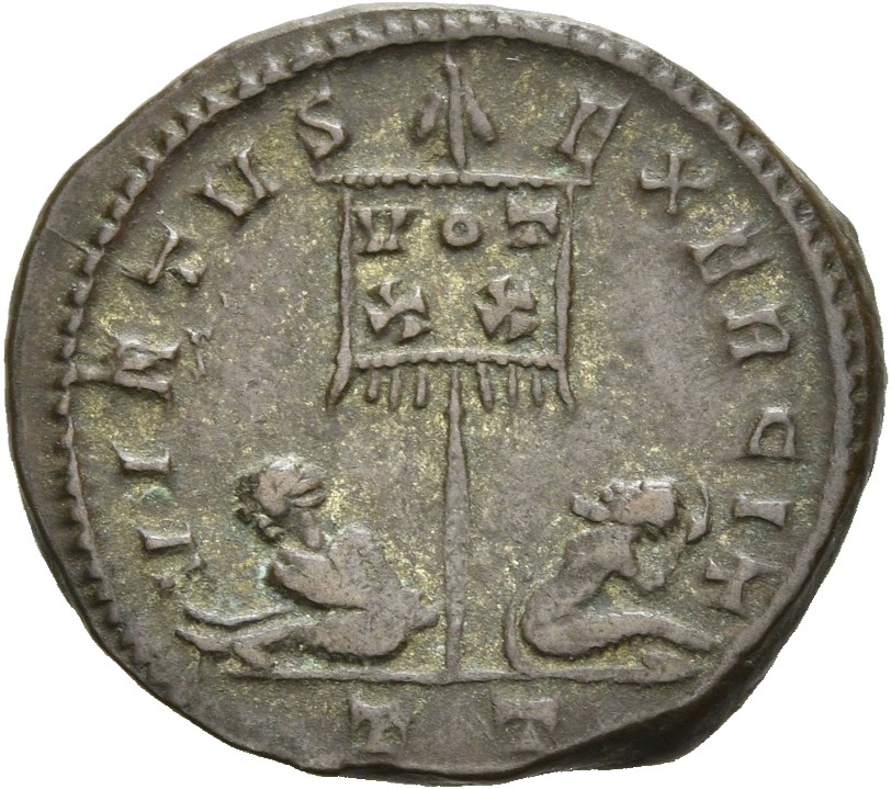RIC VII Ticinum 114 Constantine I reverse, Standard with VOT/XX inscribed on drapery, flanked by two seated captives
