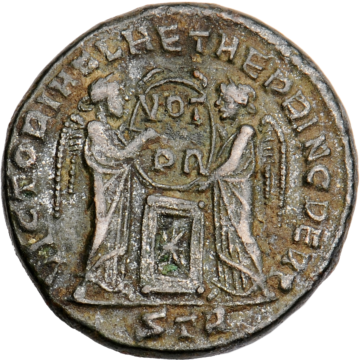 Constantine I reverse — Two Victories, winged, draped, standing facing each other, holding a shield inscribed VOT/PR supported by an altar